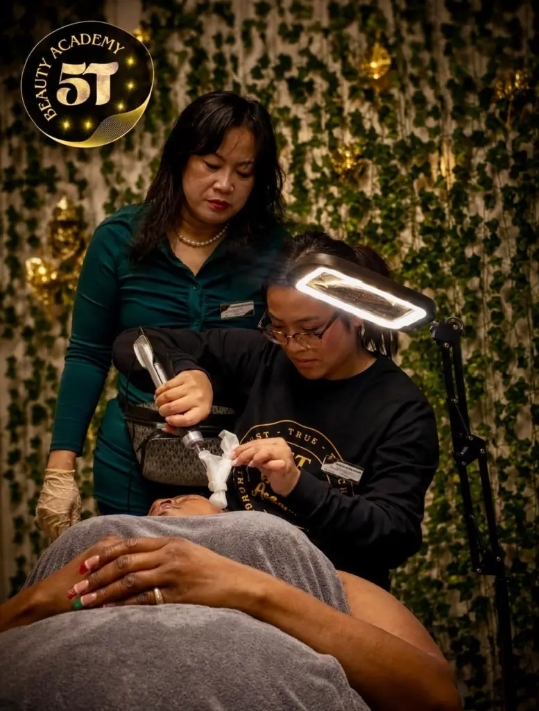 Esthetician student using professional facial machines and skincare technology during hands-on training at 5T Beauty Academy.