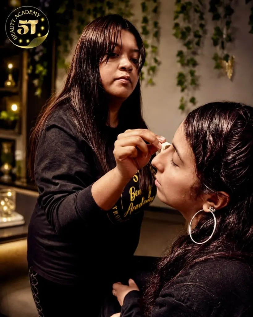 Beauty student practicing professional makeup application techniques during hands-on training at 5T Beauty Academy.