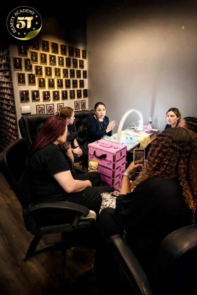 Beauty instructor guiding students through hands-on nail and beauty training at 5T Beauty Academy.